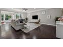 Spacious living area with hardwood floors, ample seating, modern media center, and natural light at 733 Wexford Cove Way, Mableton, GA 30126