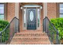 Elegant brick entryway with a black front door framed by sidelights and decorative columns at 1952 Sugarstone Dr, Lawrenceville, GA 30043