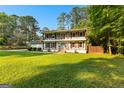 Charming two-story home with double balconies, shutters, a brick facade, and a well-manicured lawn at 103 Chipstone Ct, Peachtree City, GA 30269