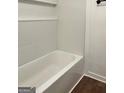 Close-up of a clean white tiled bathtub with built-in shelving at 1764 Cahoon Sw St, Atlanta, GA 30310