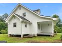 Side view of a home with light gray siding, a gray roof, and a covered porch with wooden steps at 778 Leguin Mill Rd, Locust Grove, GA 30248