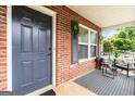 Covered front porch with stylish black and white rug and comfortable seating area at 1147 Dunivin Dr, Jonesboro, GA 30238
