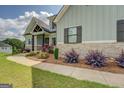 Well-manicured lawn and beautiful landscaping highlight this home's light green exterior and stone accents at 3076 East Lake Rd, Mcdonough, GA 30252