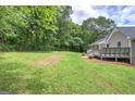 Large, level backyard with lush green grass and mature trees, perfect for outdoor activities and relaxation at 400 Kenny Ln, Temple, GA 30179