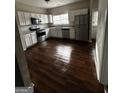 Bright kitchen featuring stainless steel appliances, white cabinets, granite countertops, and hardwood floors at 11313 Michelle Way, Hampton, GA 30228