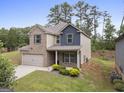 Two-story home with brick and siding, gray shutters, a two-car garage, and a well-maintained yard at 1001 Hartwell Rd, Locust Grove, GA 30248