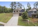 Two-story home featuring a neutral color scheme, a two-car garage, and green front lawn at 1001 Hartwell Rd, Locust Grove, GA 30248