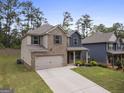 Two-story home with brick and siding, gray shutters, a two-car garage, and a well-maintained yard at 1001 Hartwell Rd, Locust Grove, GA 30248