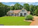 Well-kept home featuring green lawn, complemented by lush landscaping and traditional design elements at 1422 New Holland Cir, Mcdonough, GA 30252