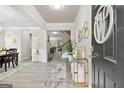 Elegant foyer featuring modern decor, a statement rug, and bright, neutral walls at 140 Canyons, Hampton, GA 30228