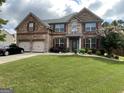 Beautiful two-story brick home with manicured lawn and attached two-car garage at 1141 Norsworthy Ml, Hampton, GA 30228