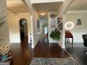 Elegant foyer with hardwood floors, decorative columns, and stylish wall art at 1141 Norsworthy Ml, Hampton, GA 30228