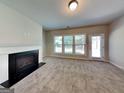 Cozy living room with a fireplace, large windows, and a neutral-toned carpet at 3712 Upland Dr, Mcdonough, GA 30253
