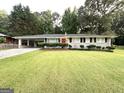 Charming one-story home with a long driveway and well-manicured lawn and front bushes at 3403 Linda Dr, Lithia Springs, GA 30122