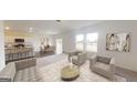 Bright, open-concept living room and kitchen, featuring stylish seating and modern appliances at 2339 Argento Cir, Dacula, GA 30019