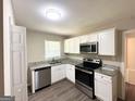 Well-lit kitchen with stainless steel appliances, granite countertops, and white cabinets at 2015 Boulderview Se Dr, Atlanta, GA 30316