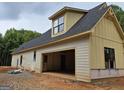 Side exterior of home showing a new construction with an attached, open two-car garage at 365 Spruill Bridge Road # 7 - Helmsley Park, Temple, GA 30179