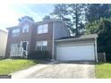 Brick and gray siding two-story home with an attached garage and a concrete driveway at 755 Kilkenny Cir, Lithonia, GA 30058