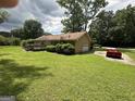A red Corvette sits outside the traditional home with a garage and long, private driveway at 8440 Winston Way, Jonesboro, GA 30236