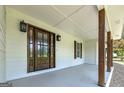 Inviting front porch with a wooden front door and decorative lighting fixtures at 858 Pates Creek Rd, Stockbridge, GA 30281