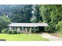 Charming brick home with mature landscaping, gray roof and attached carport at 341 Pineland Sw Rd, Mableton, GA 30126