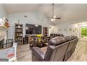 Open-concept living room with a fireplace, LVP flooring, and comfortable leather furniture at 107 Trisha Ln, Grantville, GA 30220