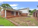 Beautiful home featuring a red brick exterior, a covered porch, and a well-manicured lawn at 5436 Ahyoka Dr, Morrow, GA 30260