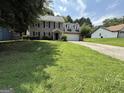 Charming two-story home with a lush green lawn and a long driveway leading to the garage at 5156 Allison Way, Sugar Hill, GA 30518