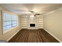 Spacious living room featuring hardwood floors, a ceiling fan, and a decorative fireplace with built-in shelving at 5670 Bob White Ln, Douglasville, GA 30135
