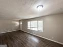 Bright living room featuring laminate floors, a large window, and neutral walls at 2500 Brentwood Rd, Decatur, GA 30032