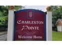 A community sign that reads 'Charleston Pointe, Welcome Home' with a pineapple emblem, set against lush greenery at 2378 Charleston Se Pt, Atlanta, GA 30316