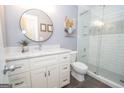 Beautiful bathroom featuring a glass-enclosed shower, updated white vanity, round mirror, and light gray paint at 220 Lavender Oasis, Peachtree City, GA 30269