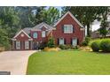 Stunning two-story brick home with lush green lawn, manicured landscaping, and traditional architectural details at 220 Lavender Oasis, Peachtree City, GA 30269