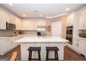 Bright kitchen featuring white cabinets, stainless steel appliances, and a large center island at 220 Lavender Oasis, Peachtree City, GA 30269