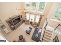 Cozy living room featuring soaring ceilings, large windows, comfortable seating, and a decorative fireplace at 220 Lavender Oasis, Peachtree City, GA 30269