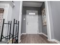 Hallway leading to the front door featuring wood-look floors and trim, with a bench at 6391 Katherine St, Douglasville, GA 30134