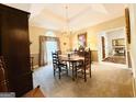 Elegant dining room with chandelier, neutral walls, and plush carpeting at 280 Emerald Lake Dr, Fayetteville, GA 30215