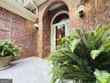 Welcoming front entrance with brick surround, decorative wreath, and manicured ferns at 280 Emerald Lake Dr, Fayetteville, GA 30215