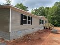Newly constructed home featuring gray siding, black shutters, block foundation, and wooden front steps at 436 Laurel Trce, Carrollton, GA 30116