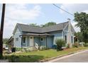 Attractive light blue home featuring a well-maintained lawn and classic architectural details at 5880 Mulberry St, Austell, GA 30168