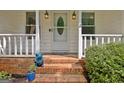 Brick steps lead to the home's front porch, with white railings and potted plants at 110 Heatherwood Dr, Fayetteville, GA 30215