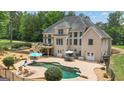 Spacious backyard with a pool, a diving board, a deck, patio seating, and mature trees at 140 Olivia Ct, Fayetteville, GA 30215