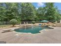 Backyard oasis featuring a private swimming pool, stone waterfall, diving board and ample seating at 140 Olivia Ct, Fayetteville, GA 30215