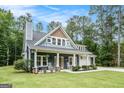 Charming home featuring a welcoming front porch with rocking chairs and well-manicured landscaping at 9148 Tarnwood Dr, Villa Rica, GA 30180