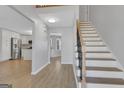 Inviting entryway with hardwood floors, a staircase with black iron spindles, and an open view into the kitchen at 3797 Churchill Sw Dr, Marietta, GA 30064