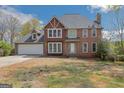 Traditional two-story brick home with attached garage and dormer window, fronted by a lawn with trees at 3797 Churchill Sw Dr, Marietta, GA 30064