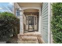 Home's front entrance featuring a brick walkway and a covered front porch with white pillars at 6448 Mobilis Ct, Sugar Hill, GA 30518