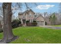 Brick home with green lawn, mature trees, and a two car garage at 6448 Mobilis Ct, Sugar Hill, GA 30518