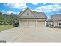 Attached three-car garage with neutral doors and a spacious driveway provides ample parking at 676 Mcbride Rd, Fayetteville, GA 30215