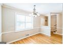 Bright dining room featuring hardwood floors, crown molding, large window, and decorative chandelier at 1099 Westfield Se Trce, Smyrna, GA 30082